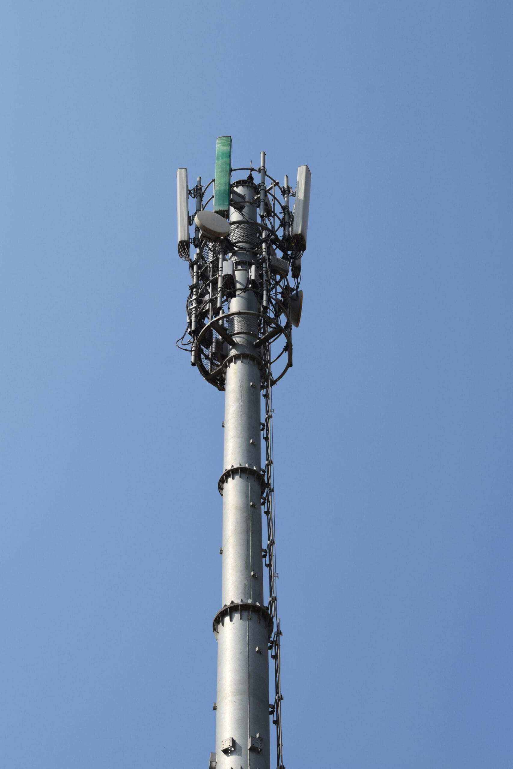 A close-up view of a communication tower reaching into the blue sky, showcasing modern technology.